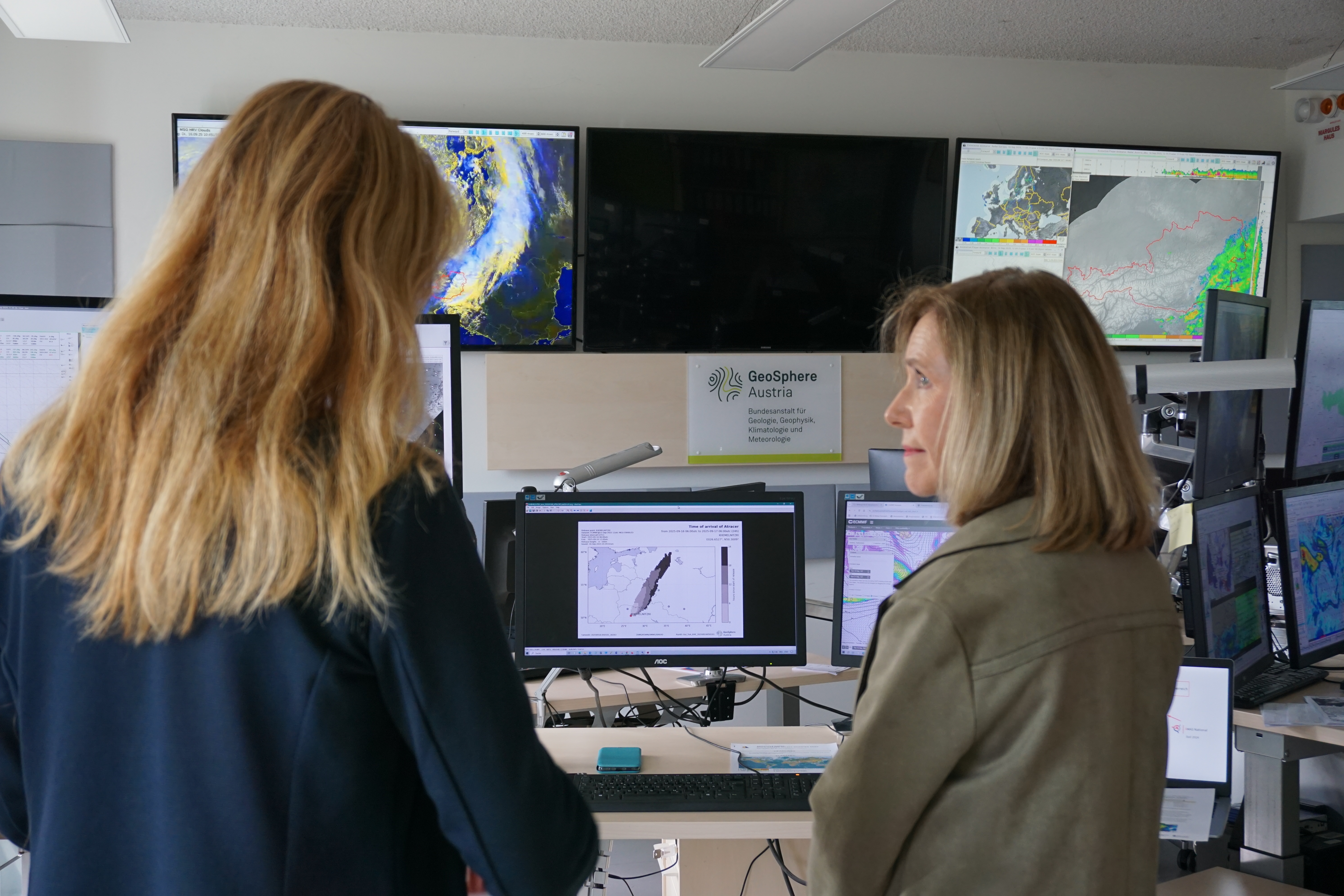 2 Frauen vor einer Wand aus Bildschirmen