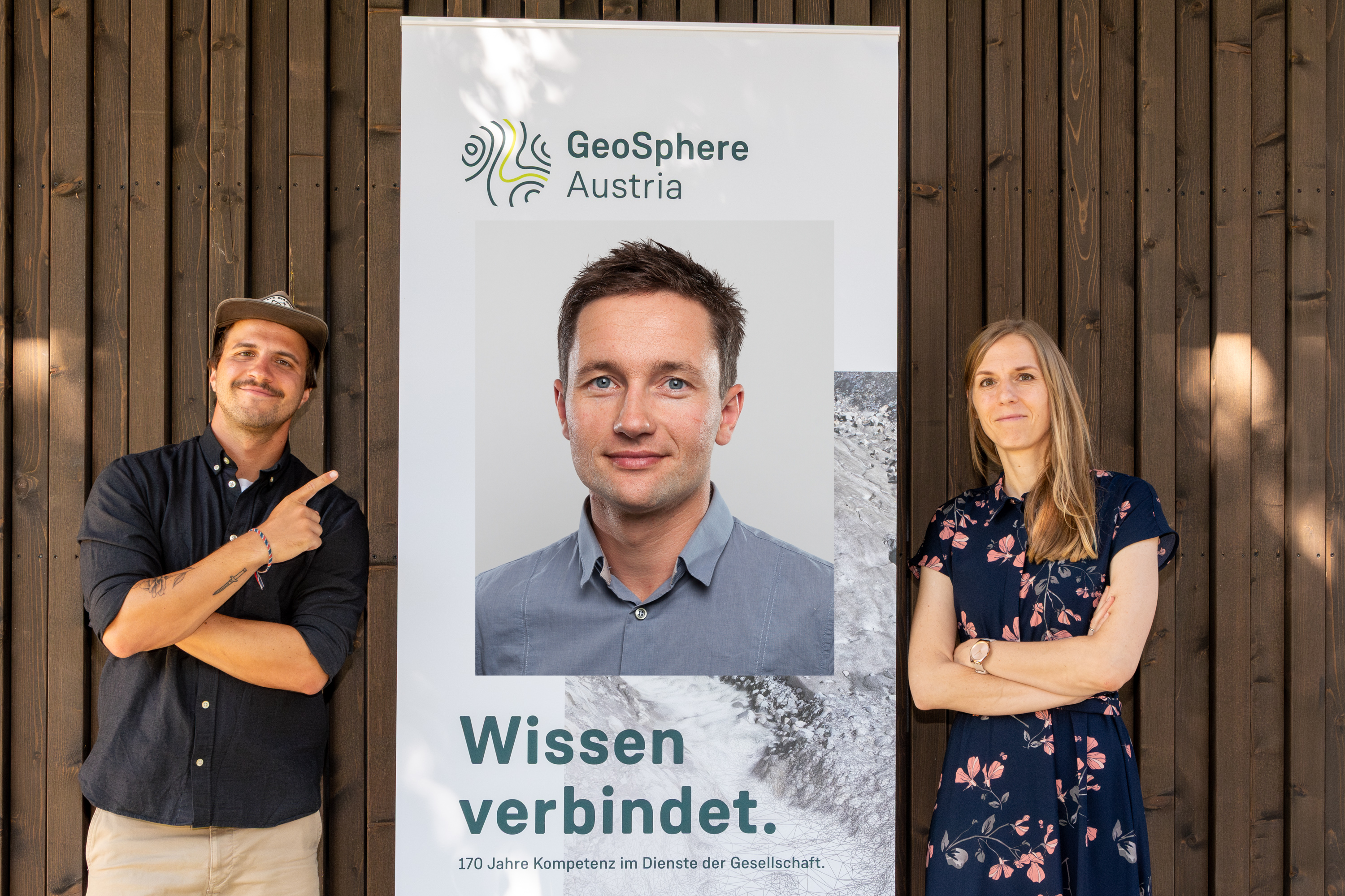 3 Personen vor einer Holzwand