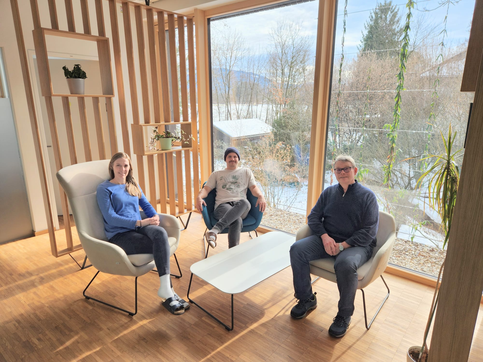 3 Personen sitzen an einem Tisch