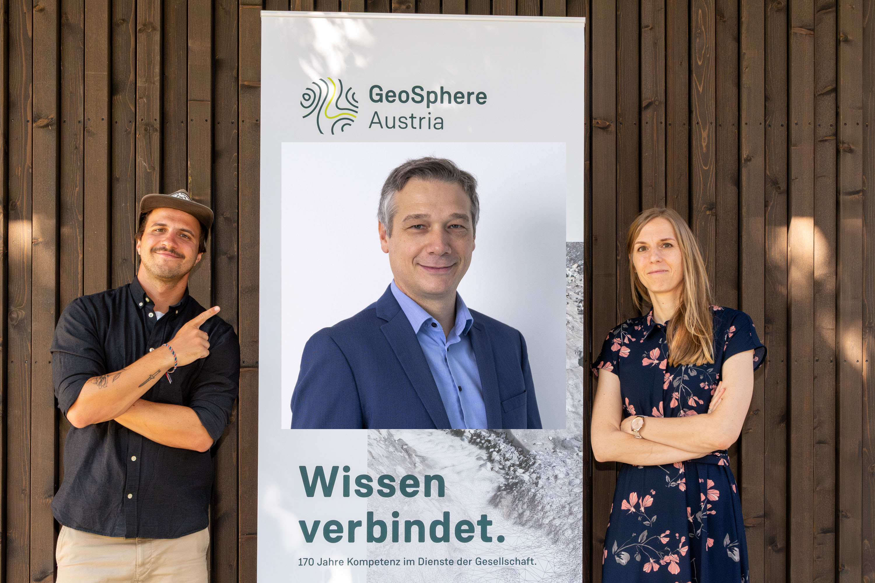 3 people in front of a wooden wall