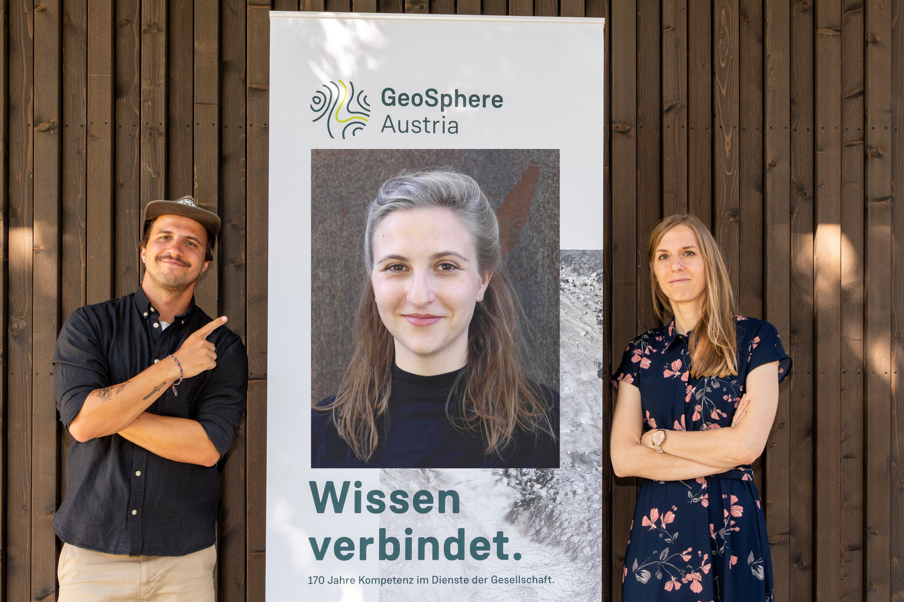 Three people in front of a wooden wall